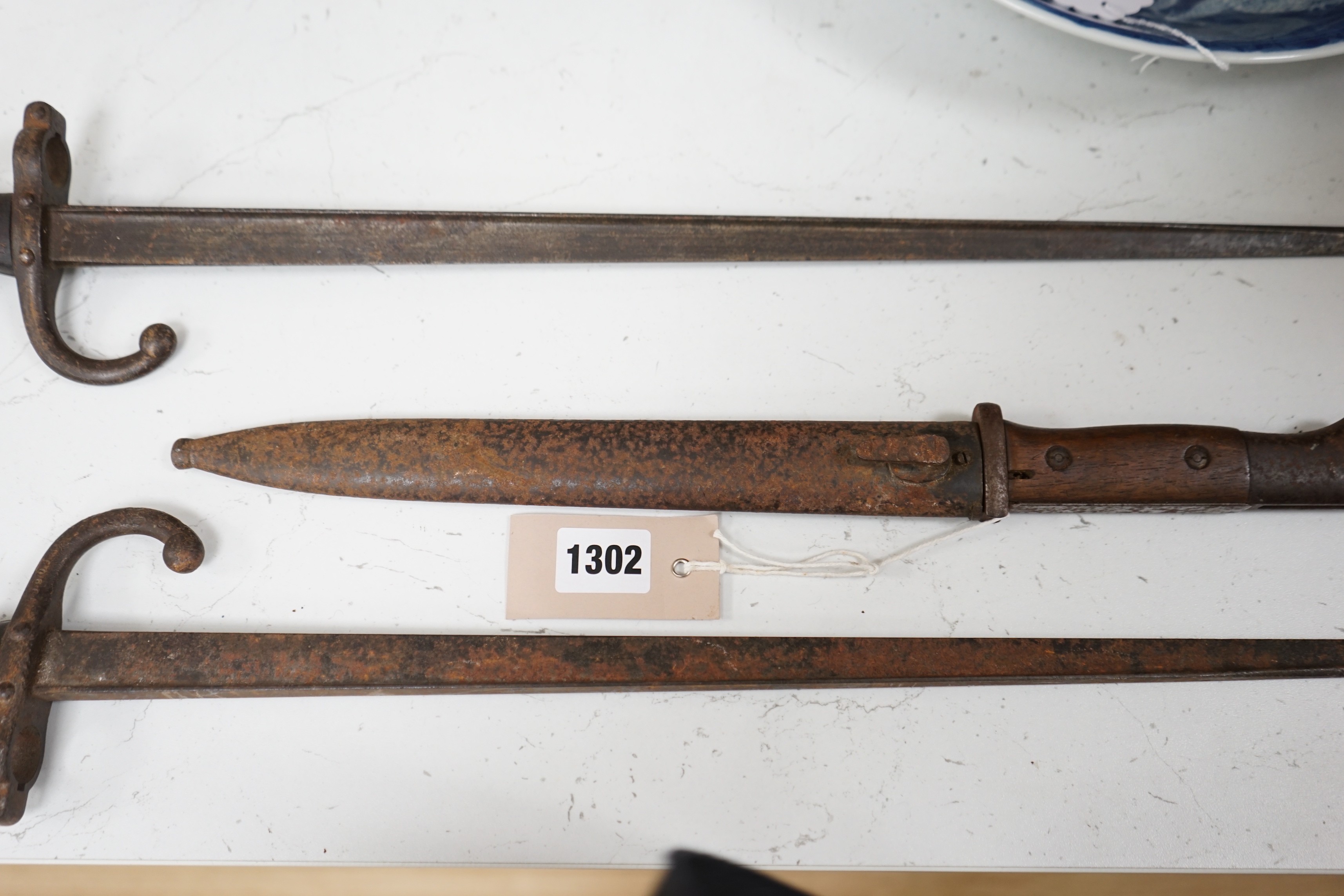 A WWI German bayonet and sheath and two other bayonets